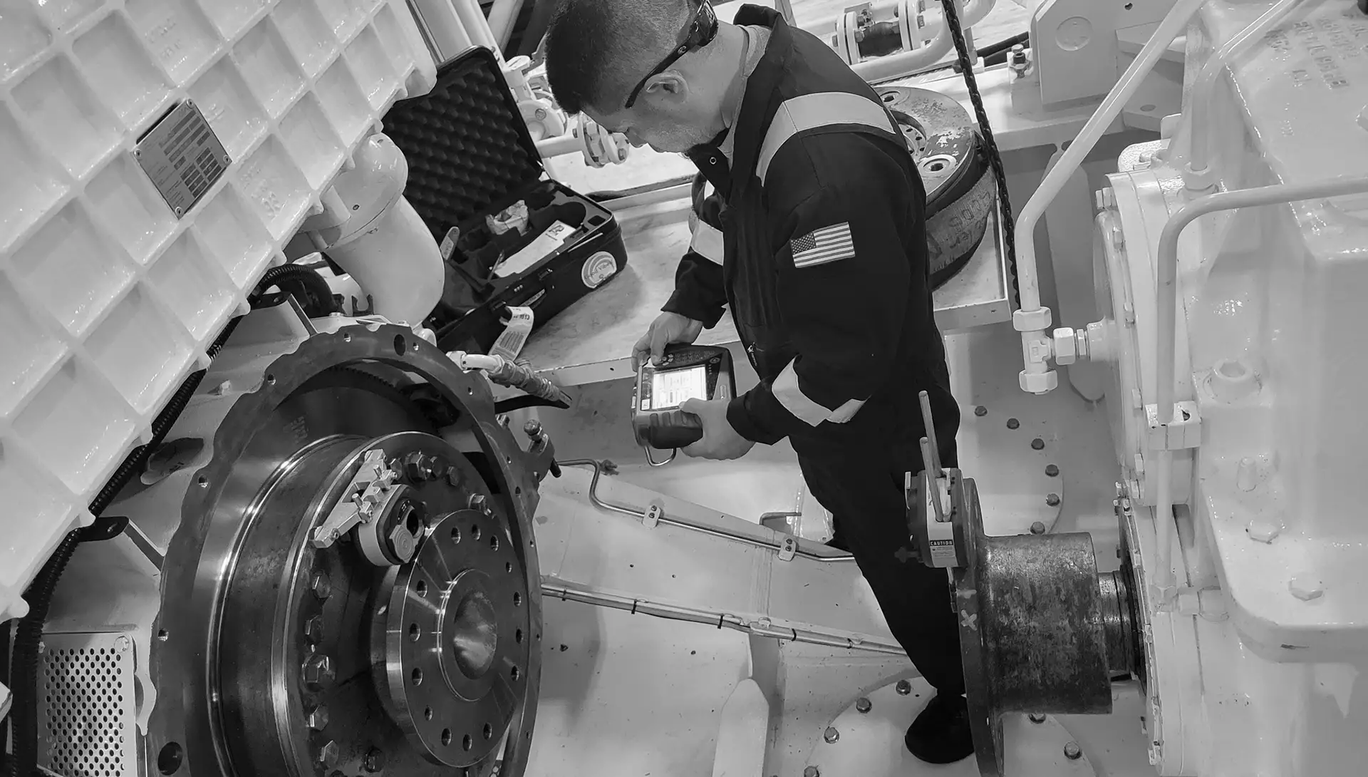 Technician performing marine condition monitoring on a vessel